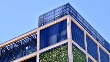 Ön cephesinde bitkiler olan yeşil ofis binası. Ekoloji ve yeşil yaşam şehirde, kentsel çevre kavramı. Çevre mimarisi. 