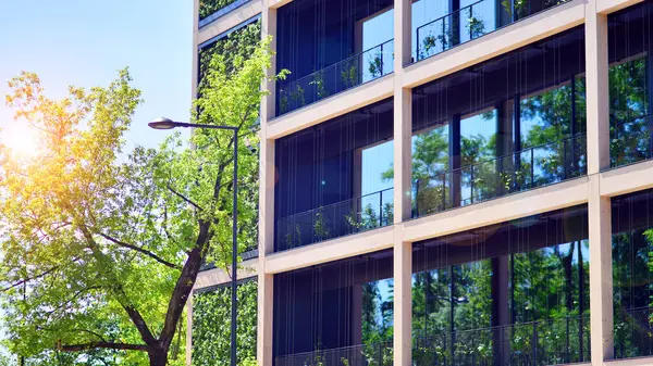 Ağaçlı modern şehir ekonomi bürosu binası. Modern mimari cephesinin detaylı görüntüleri, iş kavramları. Çevre. Modern bina ve ağaçlar, çift pozlama.