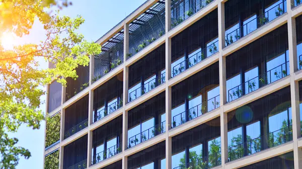 Ağaçlı modern şehir ekonomi bürosu binası. Modern mimari cephesinin detaylı görüntüleri, iş kavramları. Çevre. Modern bina ve ağaçlar, çift pozlama.