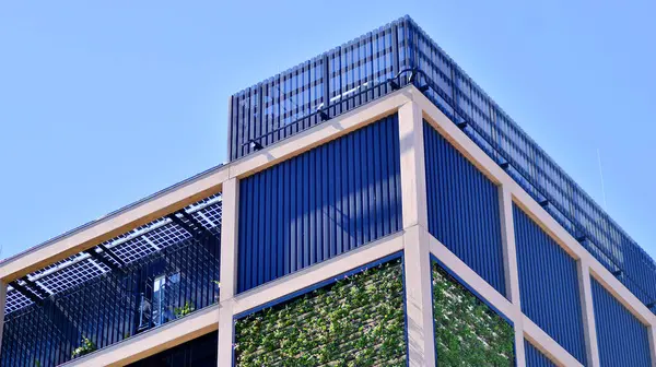 Ön cephesinde bitkiler olan yeşil ofis binası. Ekoloji ve yeşil yaşam şehirde, kentsel çevre kavramı. Çevre mimarisi. 