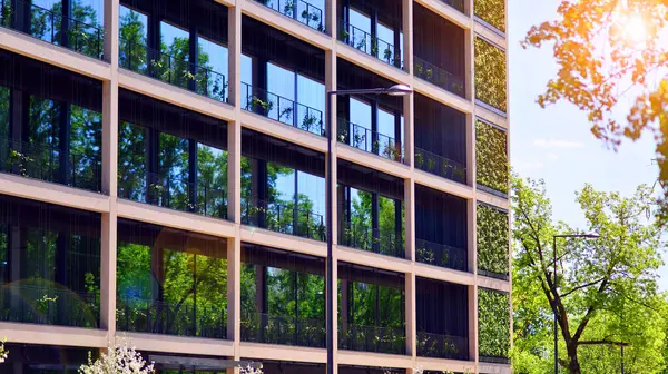 Ağaçlı modern şehir ekonomi bürosu binası. Modern mimari cephesinin detaylı görüntüleri, iş kavramları. Çevre. Modern bina ve ağaçlar, çift pozlama.