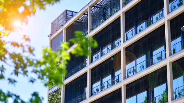 Ağaçlı modern şehir ekonomi bürosu binası. Modern mimari cephesinin detaylı görüntüleri, iş kavramları. Çevre. Modern bina ve ağaçlar, çift pozlama.