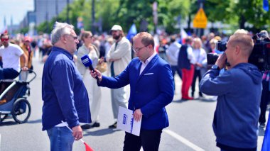 Varşova, Polonya. 25.05.2025. Rafal Trzaskowski 'nin Büyük Vatanseverler Yürüyüşü. Profesyonel gazeteci TVP 3, yürüyüşün bir katılımcısıyla röportaj yapıyor.