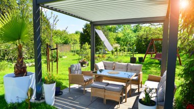 Güzel bahçesinde şık bahçe mobilyaları olan modern alüminyum pergola..