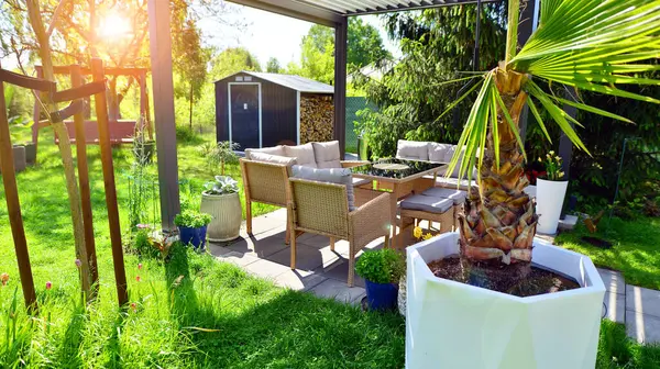 Güzel bahçesinde şık bahçe mobilyaları olan modern alüminyum pergola..