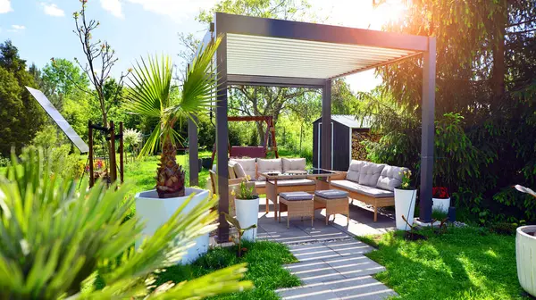 Güzel bahçesinde şık bahçe mobilyaları olan modern alüminyum pergola..