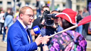 Varşova, Polonya. 25.05.2025. Rafal Trzaskowski 'nin Büyük Vatanseverler Yürüyüşü. Profesyonel gazeteci TVP 3, yürüyüşün bir katılımcısıyla röportaj yapıyor.