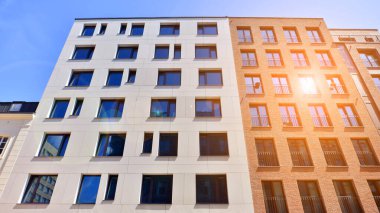 Mavi gökyüzü olan güneşli bir günde modern apartman binaları. Modern bir apartmanın ön cephesi. Modern konut binası kompleksi.