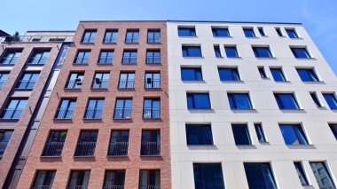 Mavi gökyüzü olan güneşli bir günde modern apartman binaları. Modern bir apartmanın ön cephesi. Modern konut binası kompleksi.