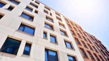 Mavi gökyüzü olan güneşli bir günde modern apartman binaları. Modern bir apartmanın ön cephesi. Modern konut binası kompleksi.