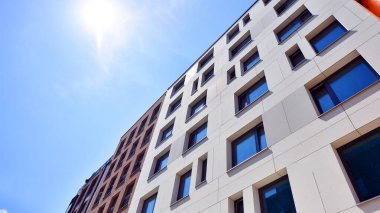 Mavi gökyüzü olan güneşli bir günde modern apartman binaları. Modern bir apartmanın ön cephesi. Modern konut binası kompleksi.