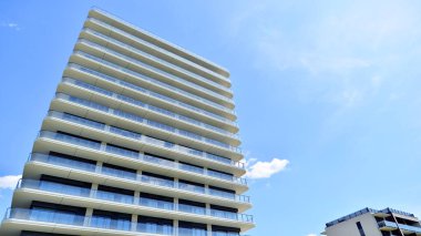 Çok katlı, modern bir apartmanın dış cephesi, pencereleri ve balkonları..