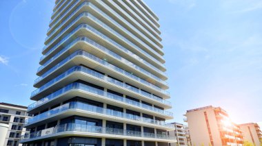 Çok katlı, modern bir apartmanın dış cephesi, pencereleri ve balkonları..