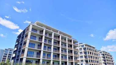 Çok katlı, modern bir apartmanın dış cephesi, pencereleri ve balkonları..