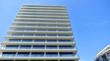 Çok katlı, modern bir apartmanın dış cephesi, pencereleri ve balkonları..