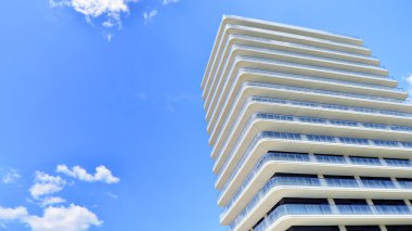 Çok katlı, modern bir apartmanın dış cephesi, pencereleri ve balkonları..