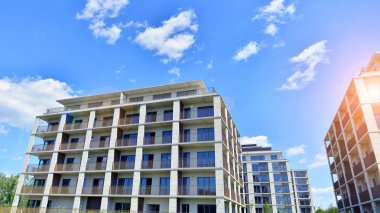 Mavi gökyüzü olan güneşli bir günde modern apartman binaları. Modern bir apartmanın ön cephesi. Modern konut binası kompleksi.