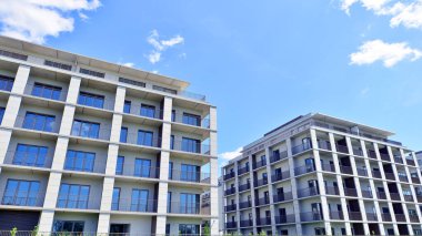Mavi gökyüzü olan güneşli bir günde modern apartman binaları. Modern bir apartmanın ön cephesi. Modern konut binası kompleksi.