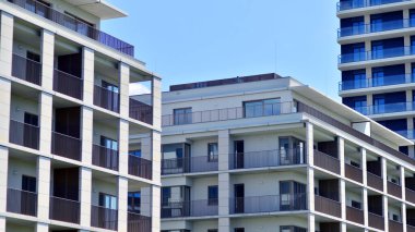 Mavi gökyüzü olan güneşli bir günde modern apartman binaları. Modern bir apartmanın ön cephesi. Modern konut binası kompleksi.
