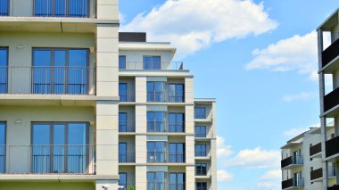 Mavi gökyüzü olan güneşli bir günde modern apartman binaları. Modern bir apartmanın ön cephesi. Modern konut binası kompleksi.