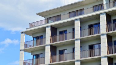 Mavi gökyüzü olan güneşli bir günde modern apartman binaları. Modern bir apartmanın ön cephesi. Modern konut binası kompleksi.