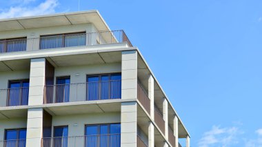 Mavi gökyüzü olan güneşli bir günde modern apartman binaları. Modern bir apartmanın ön cephesi. Modern konut binası kompleksi.