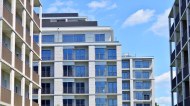 Mavi gökyüzü olan güneşli bir günde modern apartman binaları. Modern bir apartmanın ön cephesi. Modern konut binası kompleksi.