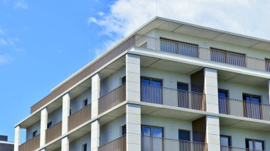 Mavi gökyüzü olan güneşli bir günde modern apartman binaları. Modern bir apartmanın ön cephesi. Modern konut binası kompleksi.