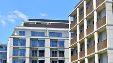 Mavi gökyüzü olan güneşli bir günde modern apartman binaları. Modern bir apartmanın ön cephesi. Modern konut binası kompleksi.