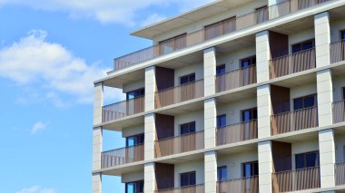 Mavi gökyüzü olan güneşli bir günde modern apartman binaları. Modern bir apartmanın ön cephesi. Modern konut binası kompleksi.