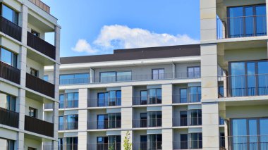 Mavi gökyüzü olan güneşli bir günde modern apartman binaları. Modern bir apartmanın ön cephesi. Modern konut binası kompleksi.