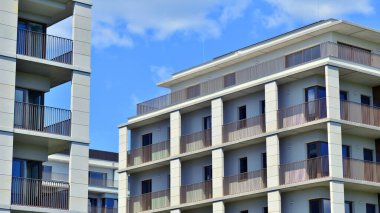 Mavi gökyüzü olan güneşli bir günde modern apartman binaları. Modern bir apartmanın ön cephesi. Modern konut binası kompleksi.