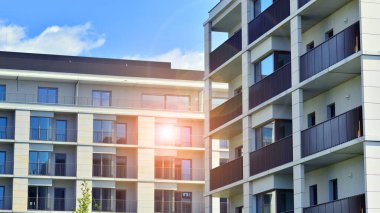 Mavi gökyüzü olan güneşli bir günde modern apartman binaları. Modern bir apartmanın ön cephesi. Modern konut binası kompleksi.