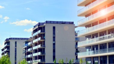 Mavi gökyüzü olan güneşli bir günde modern apartman binaları. Modern bir apartmanın ön cephesi. Modern konut binası kompleksi.