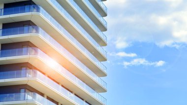 Çok katlı, modern bir apartmanın dış cephesi, pencereleri ve balkonları..