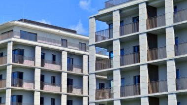 Mavi gökyüzü olan güneşli bir günde modern apartman binaları. Modern bir apartmanın ön cephesi. Modern konut binası kompleksi.
