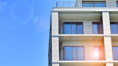 Mavi gökyüzü olan güneşli bir günde modern apartman binaları. Modern bir apartmanın ön cephesi. Modern konut binası kompleksi.