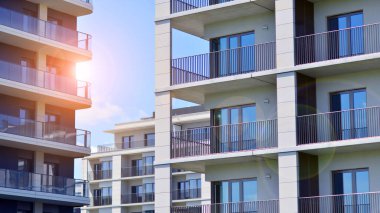 Mavi gökyüzü olan güneşli bir günde modern apartman binaları. Modern bir apartmanın ön cephesi. Modern konut binası kompleksi.