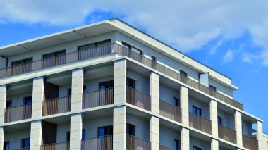 Mavi gökyüzü olan güneşli bir günde modern apartman binaları. Modern bir apartmanın ön cephesi. Modern konut binası kompleksi.