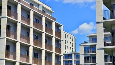 Mavi gökyüzü olan güneşli bir günde modern apartman binaları. Modern bir apartmanın ön cephesi. Modern konut binası kompleksi.