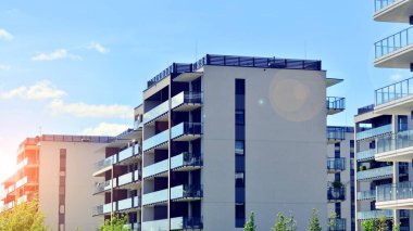 Mavi gökyüzü olan güneşli bir günde modern apartman binaları. Modern bir apartmanın ön cephesi. Modern konut binası kompleksi.