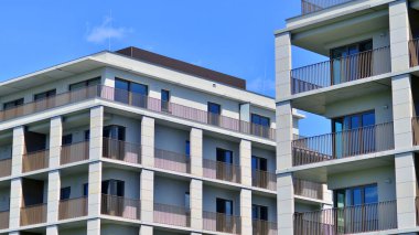 Mavi gökyüzü olan güneşli bir günde modern apartman binaları. Modern bir apartmanın ön cephesi. Modern konut binası kompleksi.