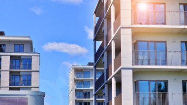 Mavi gökyüzü olan güneşli bir günde modern apartman binaları. Modern bir apartmanın ön cephesi. Modern konut binası kompleksi.