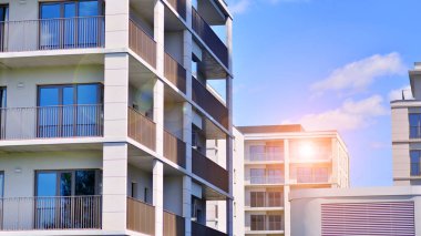 Mavi gökyüzü olan güneşli bir günde modern apartman binaları. Modern bir apartmanın ön cephesi. Modern konut binası kompleksi.