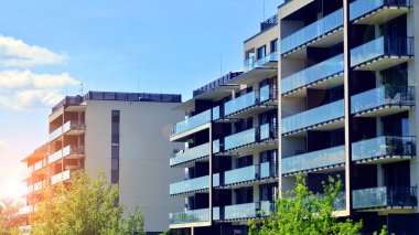 Mavi gökyüzü olan güneşli bir günde modern apartman binaları. Modern bir apartmanın ön cephesi. Modern konut binası kompleksi.