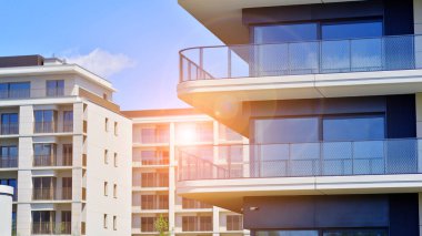 Mavi gökyüzü olan güneşli bir günde modern apartman binaları. Modern bir apartmanın ön cephesi. Modern konut binası kompleksi.