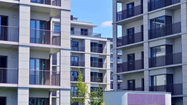 Mavi gökyüzü olan güneşli bir günde modern apartman binaları. Modern bir apartmanın ön cephesi. Modern konut binası kompleksi.