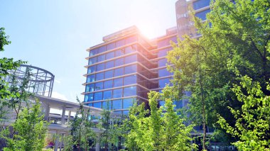 Karbondioksiti azaltmak için ağaçlı sürdürülebilir cam ofis binası. Modern şehirde çevre dostu bir bina. Yeşil çevresi olan bir ofis. Şirket binası CO2 'yi düşürdü.
