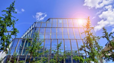 Karbondioksiti azaltmak için ağaçlı sürdürülebilir cam ofis binası. Modern şehirde çevre dostu bir bina. Yeşil çevresi olan bir ofis. Şirket binası CO2 'yi düşürdü.