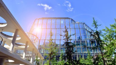 Karbondioksiti azaltmak için ağaçlı sürdürülebilir cam ofis binası. Modern şehirde çevre dostu bir bina. Yeşil çevresi olan bir ofis. Şirket binası CO2 'yi düşürdü.
